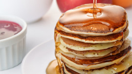 Stii life with pancakes stack pouring marple syrup